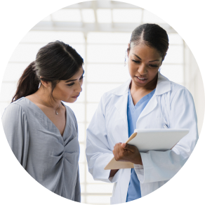 Photo image of a female doctor and adult female patient discussing information on a chart