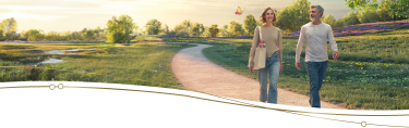 Photo image of an adult female walking with her father along a path through a field of wildflowers, followed by an engineered mechanical yellow and magenta butterfly